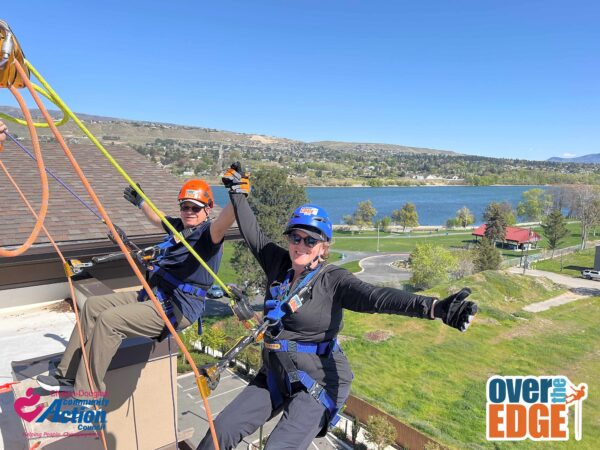 Two participants rappelling off a building